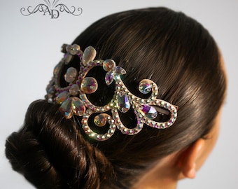 May include: A hair comb with a decorative design featuring iridescent rhinestones and a gold-tone finish. The comb is worn in a woman's hair, creating a stylish and elegant look.