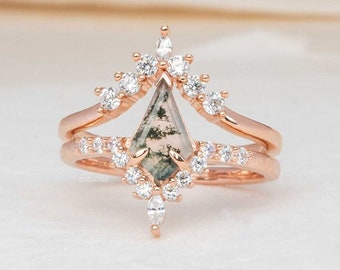 May include: A rose gold ring set with a green and gray moss agate gemstone surrounded by a halo of small diamonds. The ring is part of a two-piece set, with a delicate band featuring a row of small diamonds.
