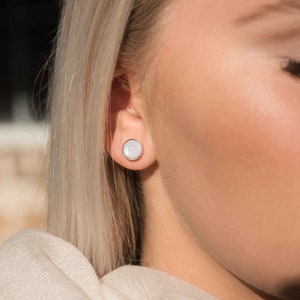 May include: A pair of silver stud earrings with white mother-of-pearl insets.
