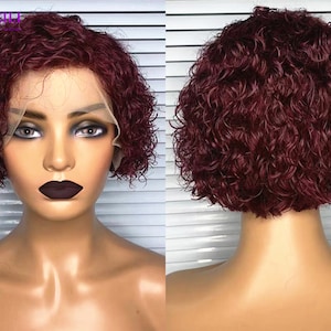 Può includere: Una parrucca corta di capelli umani ricci di colore bordeaux con un fronte in pizzo. La parrucca è acconciata a bob con ricci stretti.