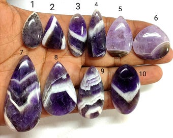 Könnte beinhalten: Zehn polierte Amethyst-Edelsteine in verschiedenen Formen und Größen, nummeriert von 1 bis 10. Die Steine zeigen Schattierungen von Violett, Weiß und Schwarz mit ausgeprägten Bänder-, Chevron- und gesprenkelten Mustern.