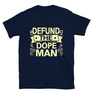 Peut inclure: Un t-shirt bleu marine avec un motif jaune qui dit "DEFUND THE DOPE MAN" avec des &eacute;toiles et des volutes.