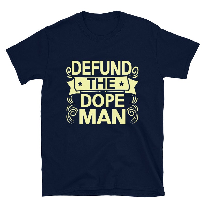 Peut inclure: Un t-shirt bleu marine avec un motif jaune qui dit "DEFUND THE DOPE MAN" avec des &eacute;toiles et des volutes.