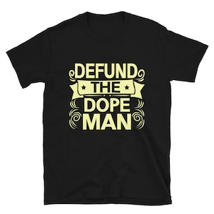 Peut inclure: T-shirt noir avec le texte "DEFUND THE DOPE MAN" en jaune.