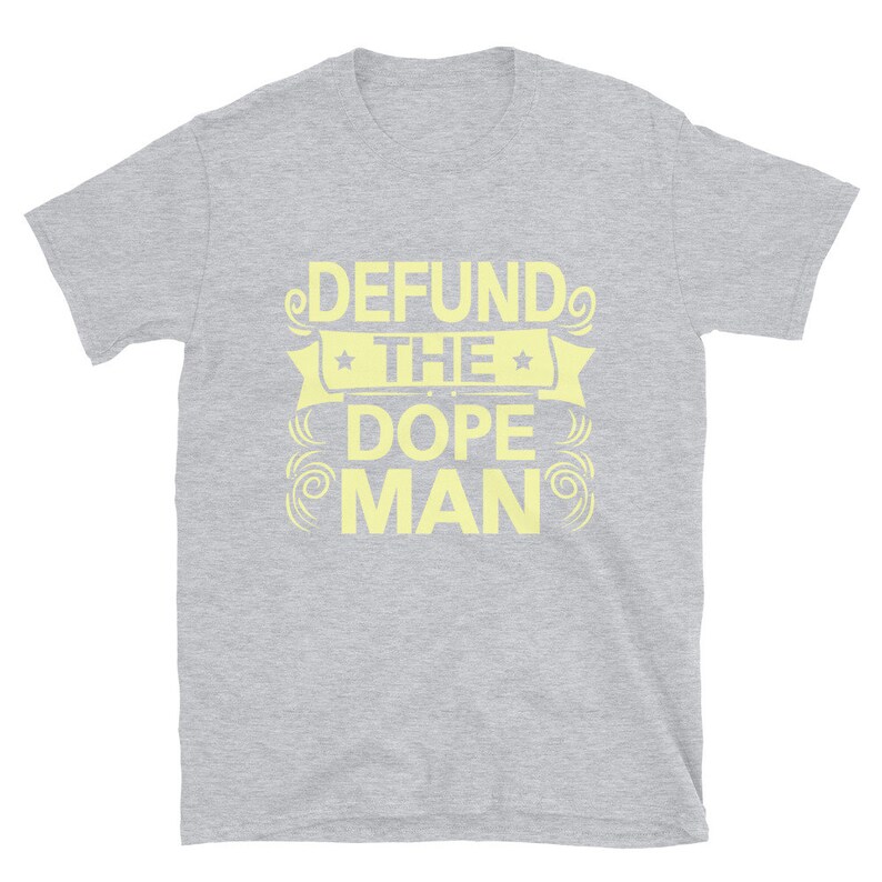Peut inclure: Un t-shirt gris &agrave; manches courtes avec le texte "DEFUND THE DOPE MAN" en jaune.