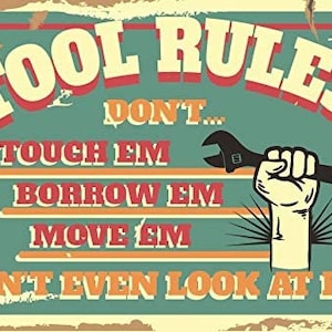 May include: A vintage-style sign with the words "TOOL RULES!" in large, bold letters. The sign features a hand holding a wrench, and the text "DON'T TOUCH EM, BORROW EM, MOVE EM, DON'T EVEN LOOK AT EM!" in a distressed font.