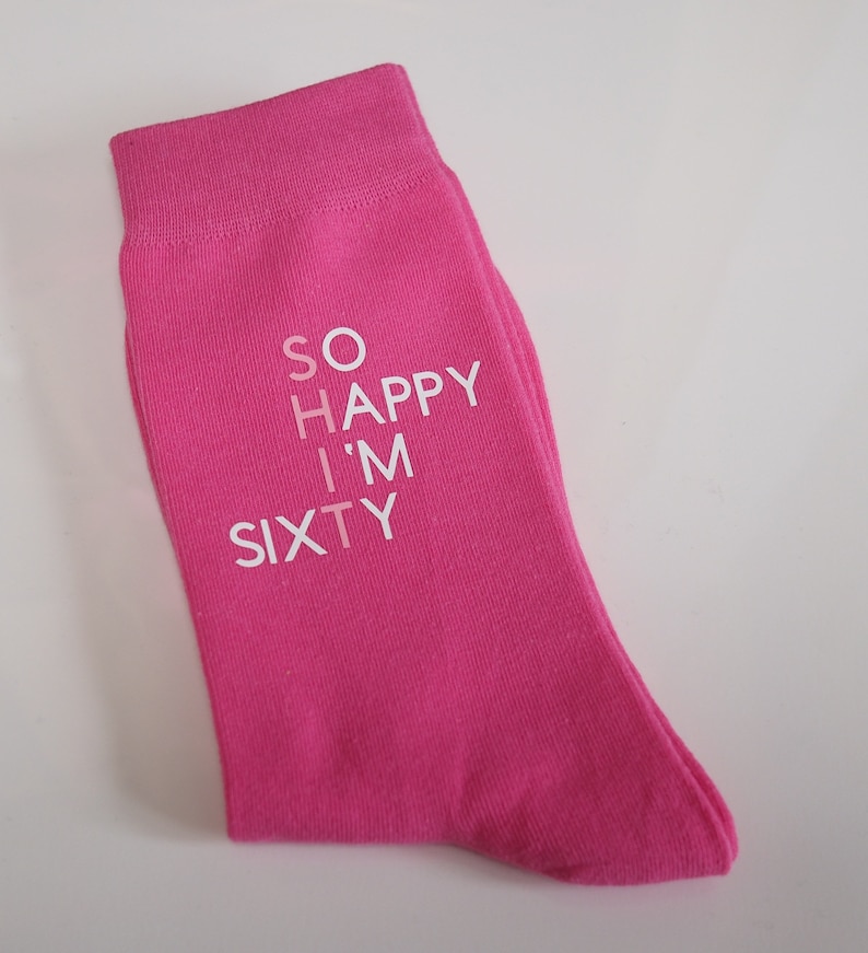 May include: Pink socks with the text "SO HAPPY I'M SIXTY" printed on them.