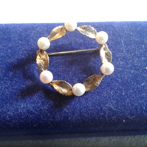 Broche couronne de feuilles en métal doré et perle de culture