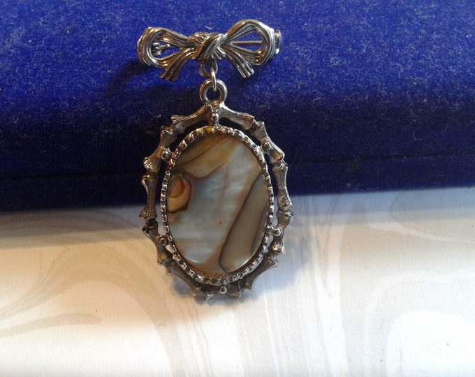 Silvertone Bow and Dangling Oval of Brown Mother of Pearl with Bamboo and Rope Frame