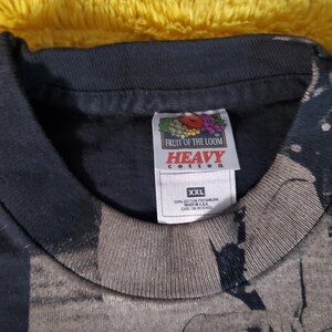 K&ouml;nnte beinhalten: Ein schwarzes Fruit of the Loom Heavy Cotton T-Shirt, Gr&ouml;&szlig;e XXL. Das Etikett zeigt das Markenlogo und den Text. Das Shirt besteht aus 100% Baumwolle und wurde in den USA hergestellt. Das Shirt hat ein verblasstes Design.