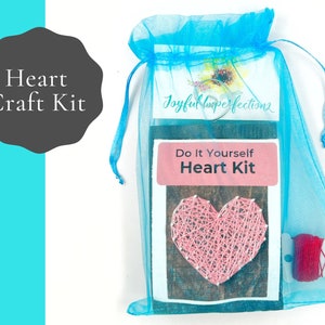 May include: A blue organza bag containing a DIY heart craft kit. The kit includes a wooden board, pink yarn, and instructions. The bag has a tag that reads "Joyful Imperfections Do It Yourself Heart Kit".