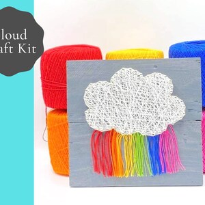 May include: A craft kit for making a string art cloud with a rainbow. The kit includes a wooden board, yarn in various colors, and nails.