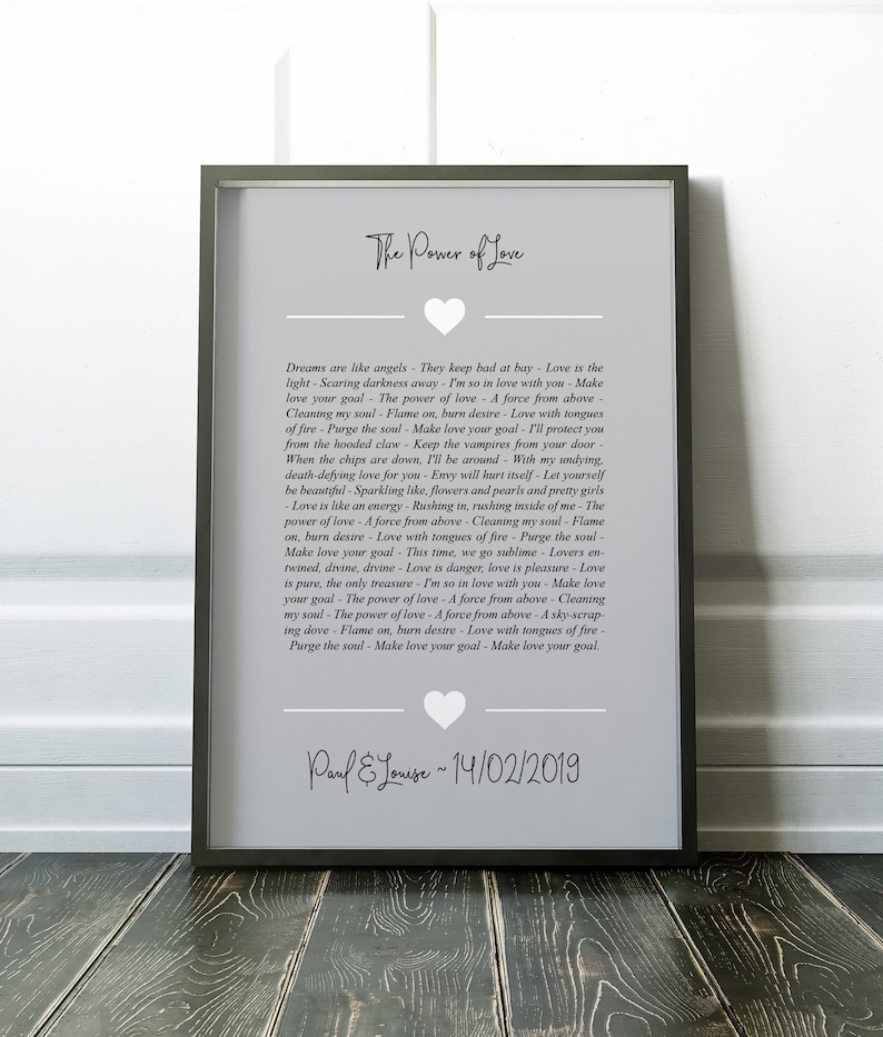 May include: A gray and white printable art print with a heart shape at the top. The print features a poem about the power of love with the text "The Power of Love" at the top and "Paul & Louise ~ 14/02/2019" at the bottom.