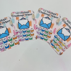 May include: Four colorful envelope challenge helper cards. Each card features a blue envelope illustration and a grid of smaller envelopes with numbers. The cards are labeled with the text "30 Envelope Challenge Helper", "50 Envelope Challenge Helper", "52 Envelope Challenge Helper", and "100 Envelope Challenge Helper".