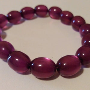 May include: A purple beaded bracelet with oval-shaped beads.