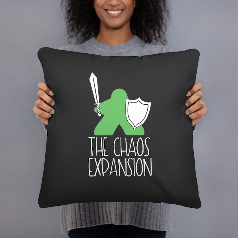 May include: Black throw pillow with a green cartoon figure holding a sword and shield. The text "THE CHAOS EXPANSION" is printed in white below the figure. The pillow is square and appears to be made of a soft fabric.