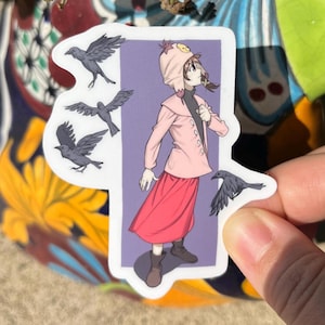 May include: A sticker featuring a cartoon girl wearing a pink hooded hat and a pink jacket. She is standing on a purple background with several black birds flying around her.