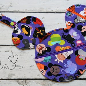 May include: Purple fabric Mickey Mouse-shaped zippered pouch with a variety of Disney character faces printed on it. The pouch has a handle and two separate zippered compartments.