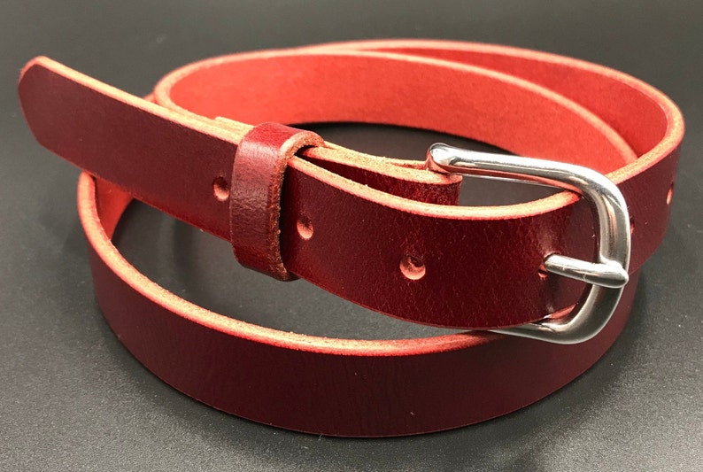 Full Grain Genuine Leather Belt in Red Color with Silver Buckle. The edges are finished and dyed to match the main leather color. The buckle is buckle and the tail place through the keeper. Chicago Screws hold the buckle onto the leather strap.