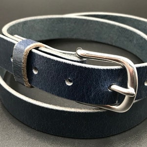 Full Grain Genuine Leather Belt in Blue Color with Silver Buckle. The edges are finished and dyed to match the main leather color. The buckle is buckle and the tail place through the keeper. Chicago Screws hold the buckle onto the leather strap.