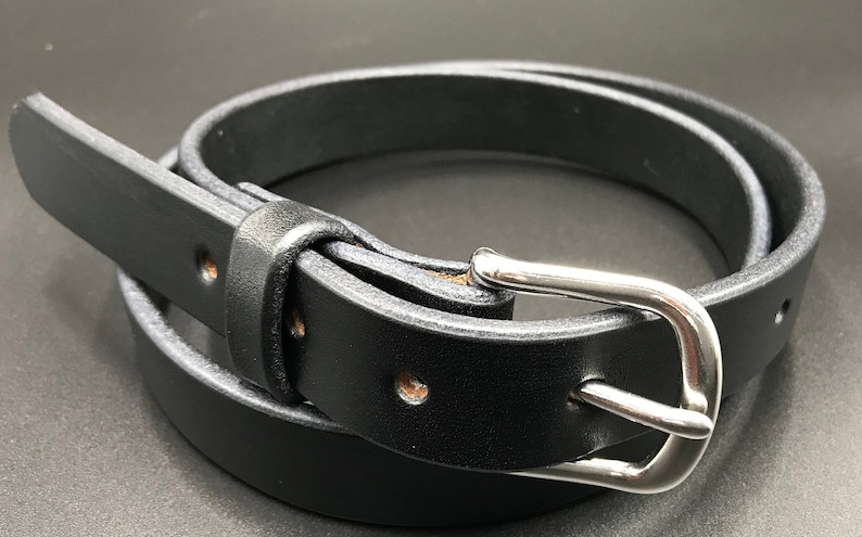 Full Grain Genuine Leather Belt in Black Color with Silver Buckle. The edges are finished and dyed to match the main leather color. The buckle is buckle and the tail place through the keeper. Chicago Screws hold the buckle onto the leather strap.