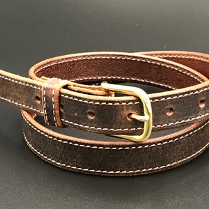 K&ouml;nnte beinhalten: Ein brauner Lederg&uuml;rtel mit wei&szlig;en N&auml;hten und einer Messing-Schnalle.