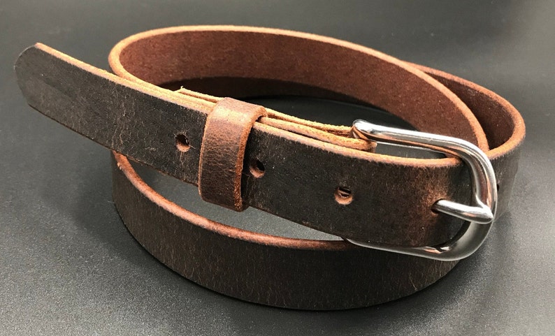 Full Grain Genuine Leather Belt in Distressed Color with Silver Buckle. The edges are finished and dyed to match the main leather color. The buckle is buckle and the tail place through the keeper. Chicago Screws hold buckle onto the leather strap.