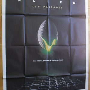 May include: A black and white movie poster for the film "Alien, Le 8e Passager" featuring a green alien egg with a yellow glow. The text on the poster reads "Alien, Le 8e Passager" and "dans l'espace, personne ne vous entend crier."