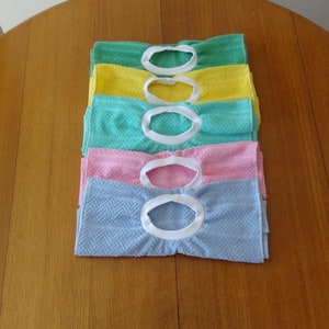 Pullover towel bibs for toddlers in blue, green, pink and yellow and aqua with white ribbed neck.