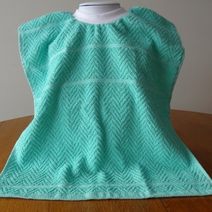 Pullover aqua toddler towel bib with white ribbed neck.