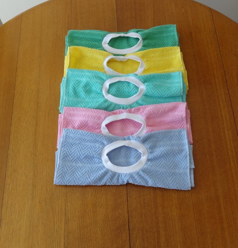 Pullover towel bibs for toddlers in blue, green, pink and yellow and aqua with white ribbed neck.