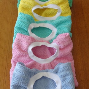 Pullover towel bibs for toddlers in blue, green, pink and yellow and aqua with white ribbed neck.