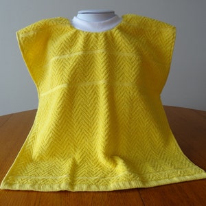 Pullover yellow toddler towel bib with white ribbed neck.