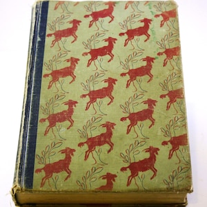 May include: A vintage book with a green cover and a repeating pattern of red goats. The goats are stylized and have a simple design.