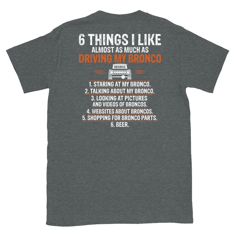 May include: A dark heather grey t-shirt with a white graphic that says "6 Things I Like Almost As Much As Driving My Bronco". The graphic also includes a black and white illustration of a Ford Bronco.