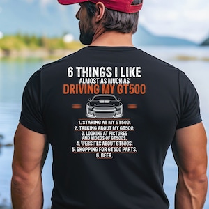 May include: A black t-shirt with white text that reads "6 THINGS I LIKE ALMOST AS MUCH AS DRIVING MY GT500". The text is followed by a list of six things the person likes, including "staring at my GT500", "talking about my GT500", "looking at pictures and videos of GT500s", "websites about GT500s", "shopping for GT500 parts", and "beer".