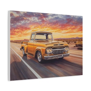 May include: A canvas print depicting a classic gold pickup truck on a highway at sunset. The truck features chrome detailing and is set against a backdrop of a vibrant orange and red sky. The road has white lines, and the desert landscape is visible in the distance.