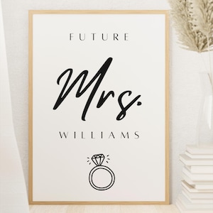 Könnte beinhalten: Ein gerahmter Druck mit dem Text "FUTURE Mrs. WILLIAMS" in schwarzer Schrift. Unter dem Text befindet sich eine einfache Strichzeichnung eines Rings mit einem Diamanten.