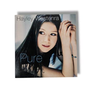 May include: Album cover featuring Hayley Westenra with long dark hair, looking to the side. The word "Pure" is written in a stylized font. The album cover is on a white background.
