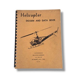 May include: A vintage "Helicopter Design and Data Book" with a spiral binding. The cover is tan with black text and a black illustration of a helicopter. The book is distributed by Helicopter Handbook in Milwaukee, Wisconsin, USA.