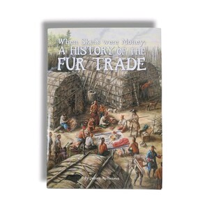 May include: A hardcover book titled "When Skins were Money: A History of the Fur Trade" with a historical illustration on the cover. The illustration depicts a scene of people in a settlement, with structures and figures engaged in various activities.