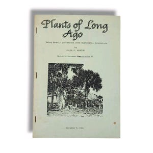 May include: A book cover with the title "Plants of Long Ago" by Julia F. Morton. The cover features a black and white photograph of a group of palm trees.