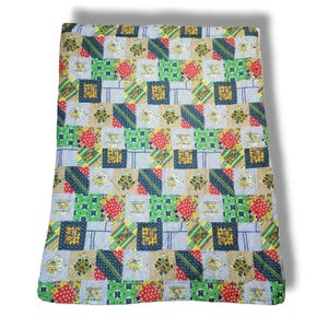 May include: A rectangular patchwork quilt featuring a repeating grid of square fabric blocks. The design incorporates a variety of patterns including floral prints, stripes, and polka dots in a vibrant color palette of red, blue, green, and yellow.