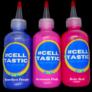 K&ouml;nnte beinhalten: Drei Flaschen Farbe mit der Aufschrift "#CELLTASTIC CELL ACTIVATOR" in Blau, Pink und Rot. Die Flaschen sind mit "Amethyst Purple", "Screamin Pink" und "Ruby Red" beschriftet.