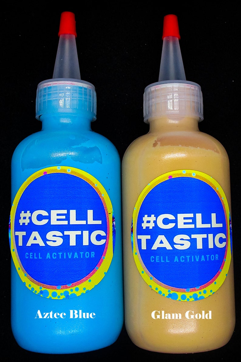 K&ouml;nnte beinhalten: Zwei Flaschen blauer und goldener Farbe mit #CellTastic Cell Activator Etiketten. Die blaue Flasche ist mit "Aztec Blue" und die goldene Flasche mit "Glam Gold" beschriftet.