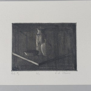 May include: A black and white print of a still life with a vase, a bowl, and a pitcher. The print is signed "K.O. Stevens" and numbered "4/7".