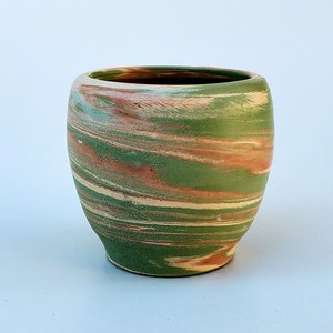 May include: A green ceramic planter with a marbled design in shades of brown and white.