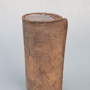May include: A brown ceramic vase with a crackled glaze finish. The vase has a cylindrical shape and a slightly uneven rim.