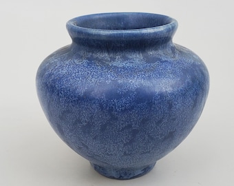 Könnte beinhalten: Eine kleine, blaue Keramikvase mit texturierter Glasur. Die Vase hat einen runden Körper und einen leicht ausgestellten Rand.