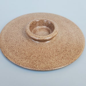 May include: A round, speckled brown ceramic serving dish with a smaller, raised round bowl in the center.